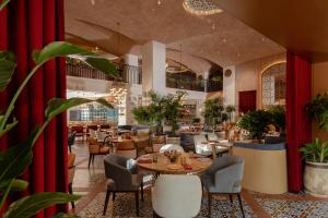 a restaurant with tables and chairs and red curtains at Doubletree By Hilton Tashkent in Tashkent