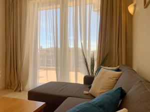 a living room with a couch and a large window at Kaliakria Pearl Resort in Topola +10 photos