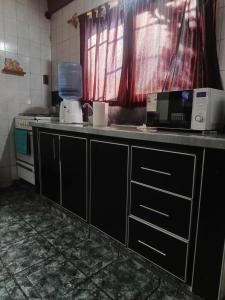 a kitchen with a counter top with a microwave at depto felix 1 in Santa Rosa