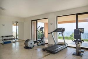 a gym with treadmills and exercise equipment and windows at Kaliakria Pearl Resort in Topola