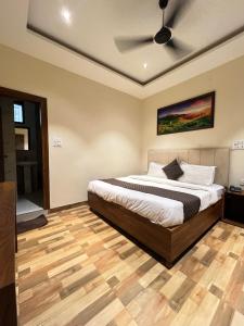 a bedroom with a bed with a ceiling fan at RS Galaxy Near AIMS Rishikesh in Rishīkesh