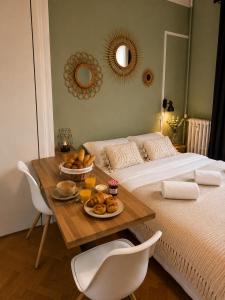 a bedroom with a bed and a table with food on it at l'Ecrin Bellevue in Aix-les-Bains