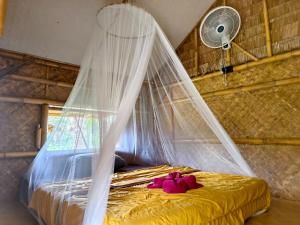 a bedroom with a bed with a mosquito net at Tarzan Bamboo hut in Khao Sok National Park