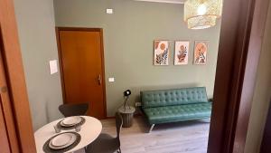 a living room with a green couch and a table at Nextop Homes in Tortona