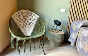 a wicker chair in a bedroom with a bed at Nextop Homes in Tortona