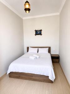 a bedroom with a large bed with white sheets at All seasons in Gonio beach in Gonio