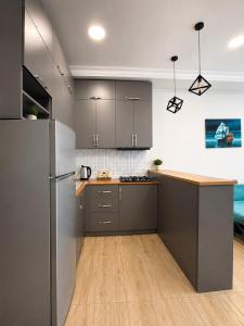 a kitchen with gray cabinets and a wooden floor at All seasons in Gonio beach in Gonio