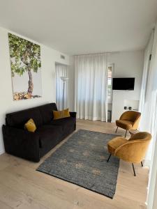 a living room with a black couch and a rug at Junior Suite agli Archetti in Torri del Benaco