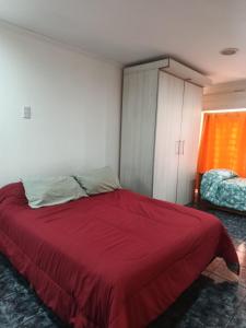 a bedroom with a red bed and a cabinet at depto felix 1 in Santa Rosa