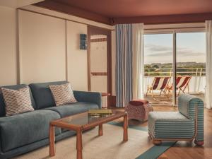 a living room with a couch and a table and chairs at Les Cimes Bleues in La Baule