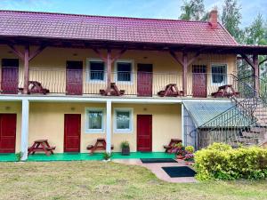 a house with red doors and a balcony at Arkadia - Amber in Jantar