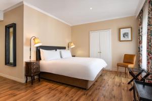 a bedroom with a large bed and a chair at Protea Hotel by Marriott Kimberley in Kimberley