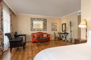 a bedroom with a bed and a chair and a mirror at Protea Hotel by Marriott Kimberley in Kimberley