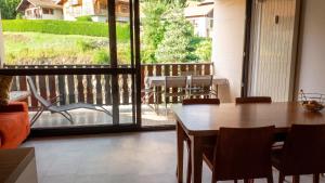 a dining room with a table and a balcony at Studio accueillant à Les Carroz, 27 m², vue montagne in Les Carroz d'Araches
