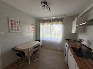 a small kitchen with a table and a table and chairs at La casita de llanda in Suances +2 photos