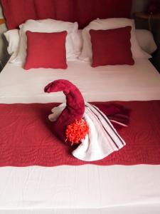 a bed with a red and white dress on it at Villa charmante au Moule avec piscine in Le Moule