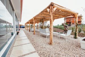 a row of white chairs under a wooden pergola at Tenuta Mari in Castelnuovo Cilento