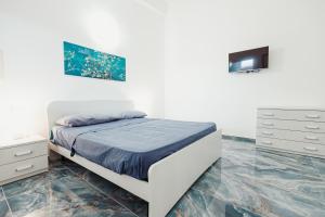 a white bedroom with a bed and a dresser at Tenuta Mari in Castelnuovo Cilento