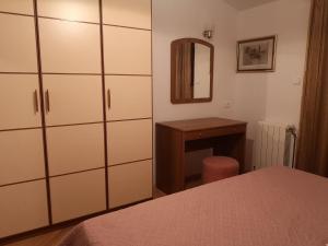 a bedroom with white cabinets and a table and a mirror at Stanka in Podgora