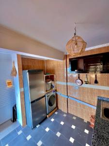 a kitchen with a stainless steel refrigerator and a microwave at Amzil Surf House in Aourir