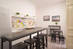 a kitchen with a counter with stools and a sink at B&B Università in Catania
