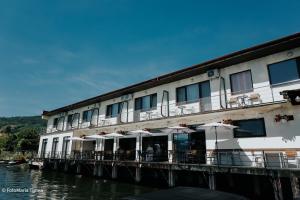 a building with tables and umbrellas next to the water at Pensiunea Damiro in Orşova