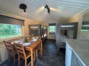 a dining room with a table in a tiny house at Hyltena Stugby in Jönköping +21 photos