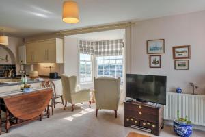 a kitchen and living room with a table and a television at Finest Retreats - Curricle in Bideford
