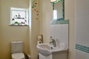 a bathroom with a sink and a toilet and a mirror at Finest Retreats - Curricle in Bideford +20 photos