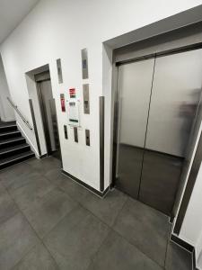 a hallway with two doors and stairs in a building at Stylish 1BR with Comfy Vibes in Beckenham +9 photos