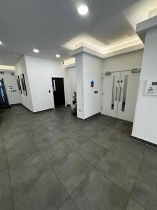a large room with white walls and a tile floor at Stylish 1BR with Comfy Vibes in Beckenham