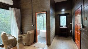 a bathroom with a tub and a toilet and a sink at บ้านเคียงธาร โฮมสเตย์ แม่แมะ Cascade Lodge Homestay in Amphoe Chiang Dao