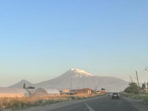 a car driving down a road with a mountain in the background at Арев in Yerevan +1 photo