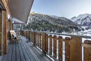 a wooden balcony with a view of a snow covered mountain at Chasa Teja by MEIN SAMNAUN - MOUNTAIN HOMES in Samnaun