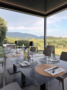 a dining area with tables and chairs and a large window at La casa del tartufo in Torri in Sabina