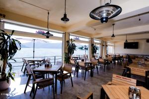 a restaurant with wooden tables and chairs and windows at Pensiunea Damiro in Orşova