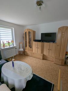 a living room with a white table and a tv at Holm in Melsungen