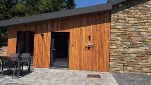 a building with a wooden door and a table at Oh la vache in Stoumont