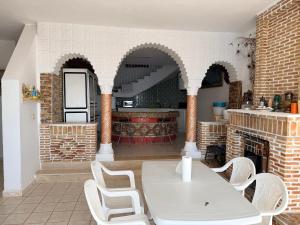 a kitchen with a white table and chairs in a room at Villa rafraf al hmeri in Rafrāf +20 photos