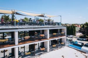 a building with people sitting on the balconies of it at Port étterem&panzió in Balatonmáriafürdő +38 photos
