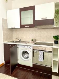 a kitchen with a washing machine and a sink at Monolocale moderno - Colazione Inclusa in Vimodrone +7 photos