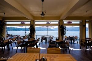 a restaurant with tables and chairs and a view of the water at Pensiunea Damiro in Orşova