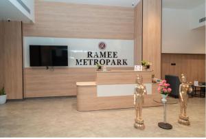 a lobby with two statues in front of a reception desk at Metro park inn in Coimbatore