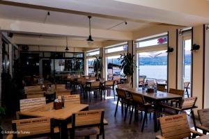 a restaurant with wooden tables and chairs and windows at Pensiunea Damiro in Orşova