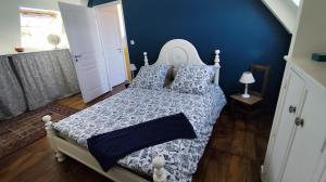 a bedroom with a bed with blue walls at Ty Maen - Étage avec chambre, coin salon, toilettes et salle de bain in Erdeven +22 photos