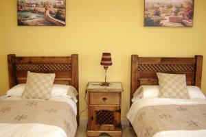 a bedroom with two beds and a lamp on a table at Idyllic House in Yegen with Mountain View in Yegen