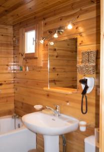 a bathroom with wooden walls and a sink and a mirror at Chalet cosy à Sixt-Fer-à-Cheval avec vue sur la montagne in Sixt