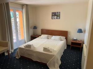 a bedroom with a bed with two towels on it at Le Relais des Templiers in Villecroze