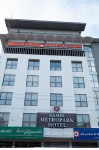a large white building with a sign on it at Metro park inn in Coimbatore