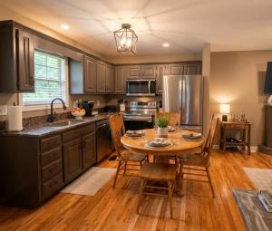 a kitchen with a wooden table with chairs and a sink at Mountain Hideaway at Cabins in the Clouds in Rising Fawn +21 photos